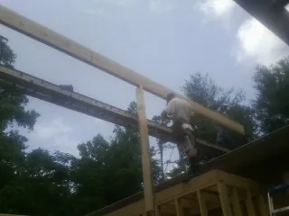 Carpenter setting a ridge beam over a new addition frame — Ice Dam Removal by Roofing Brothers in Bradyville