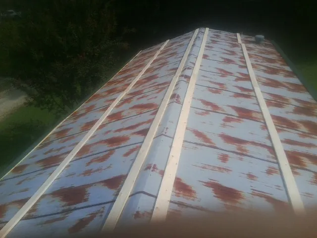 Rusted metal roof panels with new wood purlins before replacement — Storm Damage Roof Repair in Bradyville by Roofing Brothers