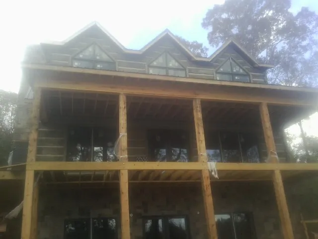 Dormers and porch framing on a large log home under construction — Roof Coating work by our crew in Bradyville